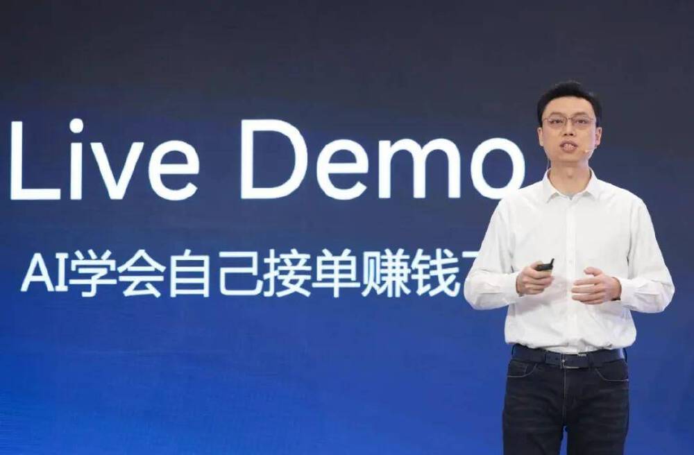 一位演讲者在智谱OpenDay活动中进行AI Agent产品现场演示，背景文字“Live Demo”及“AI学会自己接单赚钱”体现了AI实际操作能力的展示